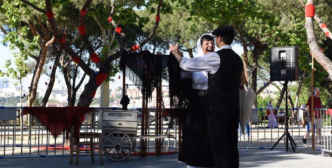 Pareja vestida con los trajes tradicionales madrileños bailando un chotis en los Jardines de las Vistillas